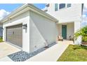 Inviting front entryway with a covered porch, stylish seating, and a well-maintained landscape at 9040 Tequila Sunrise Dr, Sarasota, FL 34241