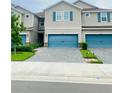 Inviting townhome exterior featuring a blue garage door, neutral siding, and a paved driveway at 11613 Woodleaf Dr, Lakewood Ranch, FL 34211