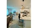 Open concept living area with barstool seating at the kitchen island and natural light throughout at 11613 Woodleaf Dr, Lakewood Ranch, FL 34211