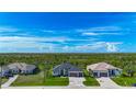 Expansive aerial shot showcasing three homes with meticulously maintained lawns and picturesque natural surroundings at 1167 Boundary Blvd, Rotonda West, FL 33947
