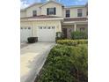 Charming townhouse featuring a red door, two-car garage, and well-maintained landscaping at 1209 Jonah Dr, North Port, FL 34289