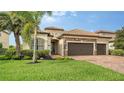 Well maintained home with a stone accented front, two-car garage, manicured lawn, and desert landscaping at 13220 Swiftwater Way, Lakewood Ranch, FL 34211