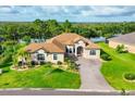 Charming home featuring a well-kept lawn, tropical landscaping, and a tranquil waterfront view at 13503 22Nd E Ct, Parrish, FL 34219