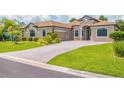 Attractive single-Gathering home with a brick driveway, attached two-car garage, and manicured front lawn at 13503 22Nd E Ct, Parrish, FL 34219