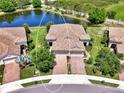 Overhead view of a home near a pond with a terra cotta-colored tile roof at 1375 Backspin Dr, Englewood, FL 34223