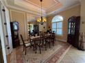 Elegant dining room with a tray ceiling, chandelier, large window, and classic furnishings at 14714 5Th Ne Ter, Bradenton, FL 34212