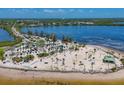Wide shot of a public beach with palm trees and many people at 1500 Sunset Rd # B4, Tarpon Springs, FL 34689