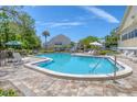 Beautiful community pool with lush green trees and lounge chairs at 1500 Sunset Rd # B4, Tarpon Springs, FL 34689