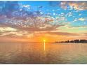 Beautiful waterfront view of the ocean with a colorful sunset reflecting on the water at 1500 Sunset Rd # B4, Tarpon Springs, FL 34689
