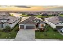 An aerial view of a luxurious residence with a paver driveway, lawn, and picturesque waterfront views at 15344 Serene Shores Loop, Bradenton, FL 34211