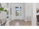 Bright foyer with glass front door, neutral tile flooring, and views into other rooms at 15344 Serene Shores Loop, Bradenton, FL 34211