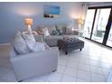 Serene living area with sofas, ottoman, and sliding glass doors to the outdoor patio at 1801 Gulf N Dr # 207, Bradenton Beach, FL 34217
