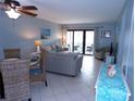 Open concept living area with tile floors and access to an outdoor balcony at 1801 Gulf N Dr # 207, Bradenton Beach, FL 34217