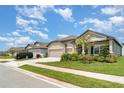 A single-Gathering home with a three-car garage, complemented by lush greenery and well-maintained landscaping at 2108 Citrus Breeze Dr, Bradenton, FL 34208