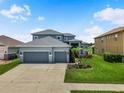 Charming two-story home with a manicured lawn, three-car garage, and beautiful curb appeal at 2347 123Rd E Pl, Parrish, FL 34219