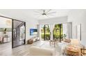 Bright living room with access to a glass-enclosed office, plush seating, and outdoor views at 2383 Lakeside Mews # D3, Sarasota, FL 34235