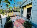 A quaint tiled patio showcasing lush landscaping and a secure entry door at 2607 29Th W Ave, Bradenton, FL 34205