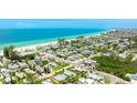 Aerial view of turquoise home near a pristine sandy beach and clear blue ocean at 2713 Avenue C, Holmes Beach, FL 34217