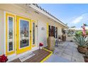 Close-up of a brightly painted front door with decorative glass and potted plants enhancing the curb appeal at 2807 Coral Way, Punta Gorda, FL 33950