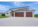 Striking house featuring a modern design with a white exterior and wood-paneled garage doors at 289 Long Meadow Ln, Rotonda West, FL 33947