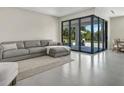 Open-concept living room with a gray sectional and large sliding doors leading to the outdoor area at 289 Long Meadow Ln, Rotonda West, FL 33947