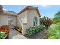 Inviting front entrance with a glass door, complemented by colorful flowers and plants at 4198 Vallarta Ct # 3027, Sarasota, FL 34233