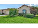 A lush front lawn with manicured landscaping, including shrubs and a palm tree at 4198 Vallarta Ct # 3027, Sarasota, FL 34233