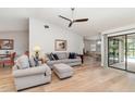 Bright living room with hardwood floors, comfortable seating, and sliding glass doors to an outdoor pool at 4353 Indian Point Trl, Sarasota, FL 34238