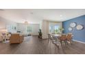 Open-concept living and dining area featuring modern decor, wood floors, and bright natural light at 4425 Boxelder Avenue, Parrish, FL 34219