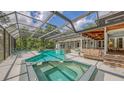 Backyard view of the screened-in pool and spa area, complete with a covered lanai and lush landscaping at 4511 Windsor Park, Sarasota, FL 34235
