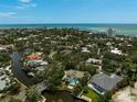 Breathtaking aerial view of the waterfront community with lush greenery, private docks, and stunning ocean views at 4831 Primrose Path, Sarasota, FL 34242
