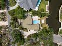 An aerial view of a private home showcasing a pool, landscaped backyard, and waterway access at 4831 Primrose Path, Sarasota, FL 34242