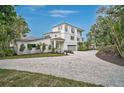 Charming two-story home featuring a paved driveway, attached garage, and lush landscaping at 4831 Primrose Path, Sarasota, FL 34242