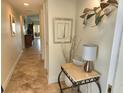 Inviting hallway with travertine floors leads to the open living space, showcasing neutral tones and elegant decor at 4832 Independence Dr, Bradenton, FL 34210