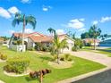 Beautiful single-story home with well-manicured lawn, lush landscaping and a brick driveway under a sunny blue sky at 4907 Kilty E Ct, Bradenton, FL 34203