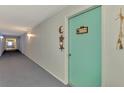 Carpeted hallway with natural lighting, leading to individual condo units at 519 Albee Farm Rd # 212, Venice, FL 34285