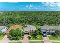 Scenic aerial view of the property with mature landscaping, brick driveway, and a lush green space backdrop at 5307 65Th E Ter, Ellenton, FL 34222