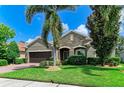 Inviting single-Gathering home with brick accents, a two-car garage, lush landscaping, and a well-manicured lawn at 5307 65Th E Ter, Ellenton, FL 34222