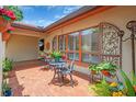 Charming patio area with wrought iron furniture, potted flowers, and decorative window accents at 5349 Everwood Run, Sarasota, FL 34235