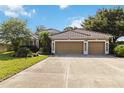 Lovely single-story home with a three-car garage, lush landscaping, and a tile roof at 5401 Oak Grove Ct, Sarasota, FL 34233