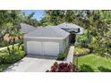Charming home featuring a well-manicured lawn, vibrant landscaping, and a two-car garage at 5508 Whitehead St, Bradenton, FL 34203