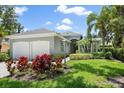 Charming home featuring a well-manicured lawn, vibrant landscaping, and a two-car garage at 5508 Whitehead St, Bradenton, FL 34203