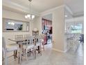 Well-lit dining room complemented by modern lighting fixtures and a view of the adjacent kitchen and breakfast bar at 5528 Palmer Cir # 104, Bradenton, FL 34211