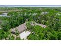 Aerial view of home with beautiful lush surroundings and an extra long driveway at 5935 River Forest Cir, Bradenton, FL 34203