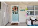 Charming front door with a floral wreath, coastal decor, and welcome mat creating an inviting entrance at 5948 Mirror Lake Rd, Sarasota, FL 34238