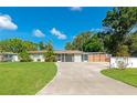 Charming single-story home with a well-manicured lawn and a long driveway leading to a screened in patio at 5948 Mirror Lake Rd, Sarasota, FL 34238