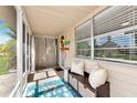 View of the porch, featuring a seating area, outdoor rug, and a charming entrance creating an inviting space at 5948 Mirror Lake Rd, Sarasota, FL 34238