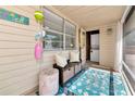 View of the porch decorated with outdoor furniture, fun decor, and a bright blue rug adding coastal charm at 5948 Mirror Lake Rd, Sarasota, FL 34238