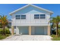 Inviting elevated beach house with blue shingle roof and two-car covered parking at 616 Fern St, Anna Maria, FL 34216