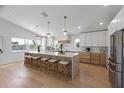 Spacious kitchen boasts a large island with seating, stainless steel appliances, and light hardwood floors at 616 Fern St, Anna Maria, FL 34216